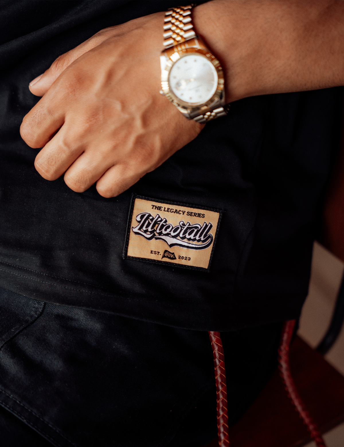 Close-up of the woven Legacy Series hem patch on a black T-shirt.